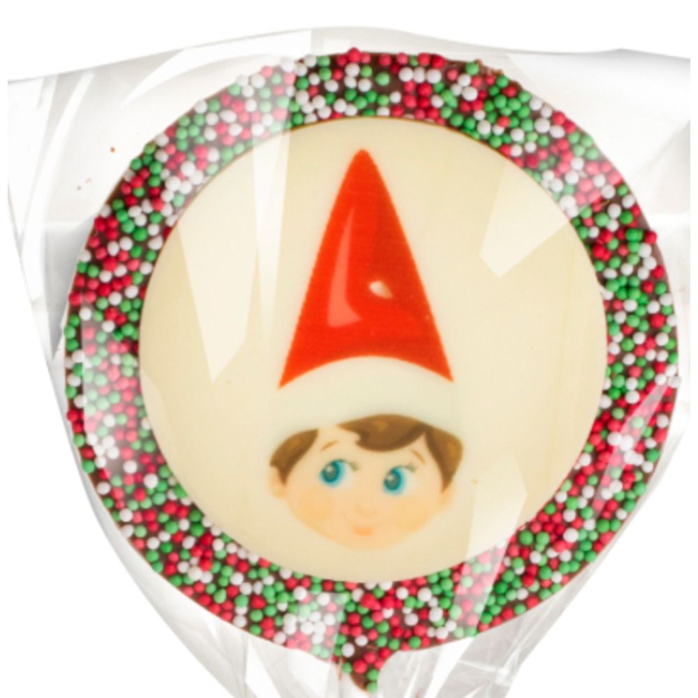 White chocolate pixie plaque surrounded by red, green and white sprinkles.